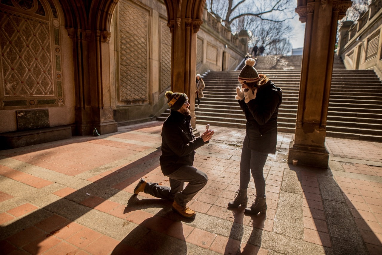 To her surprise, a man proposes to a woman at the base of some stairs