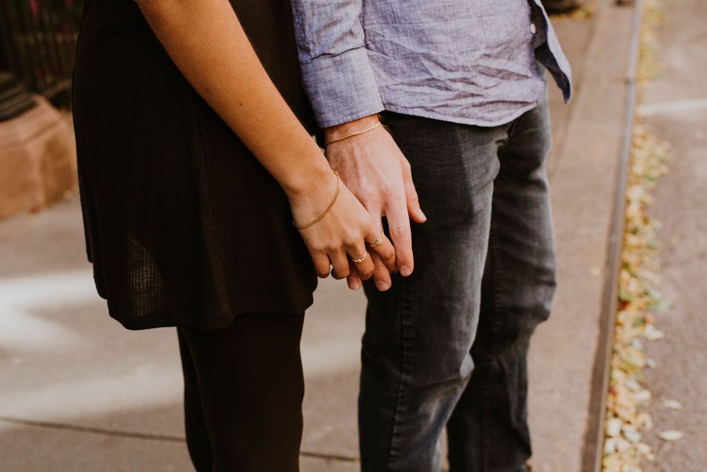 Couple holding hands on the side of the road