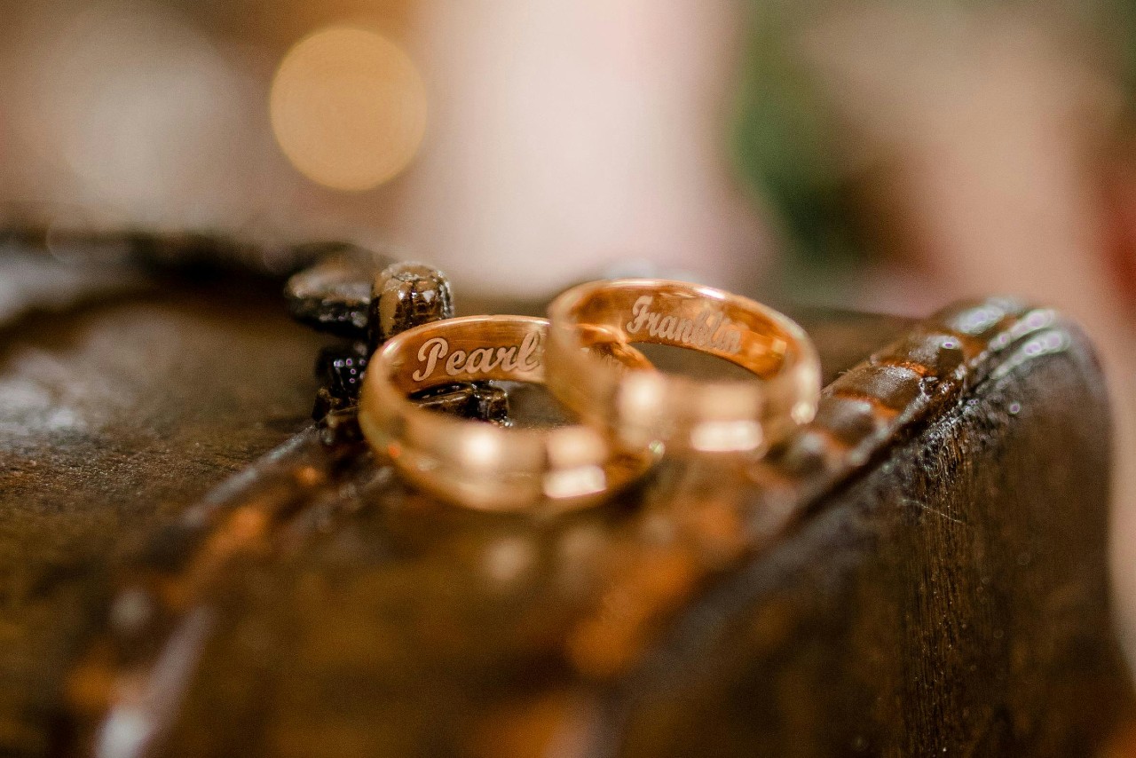 Two gold wedding bands engraved with the names 