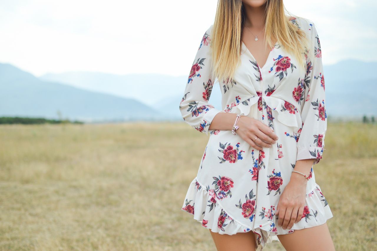 a lady standing in a field wearing platinum bracelets and other jewelry