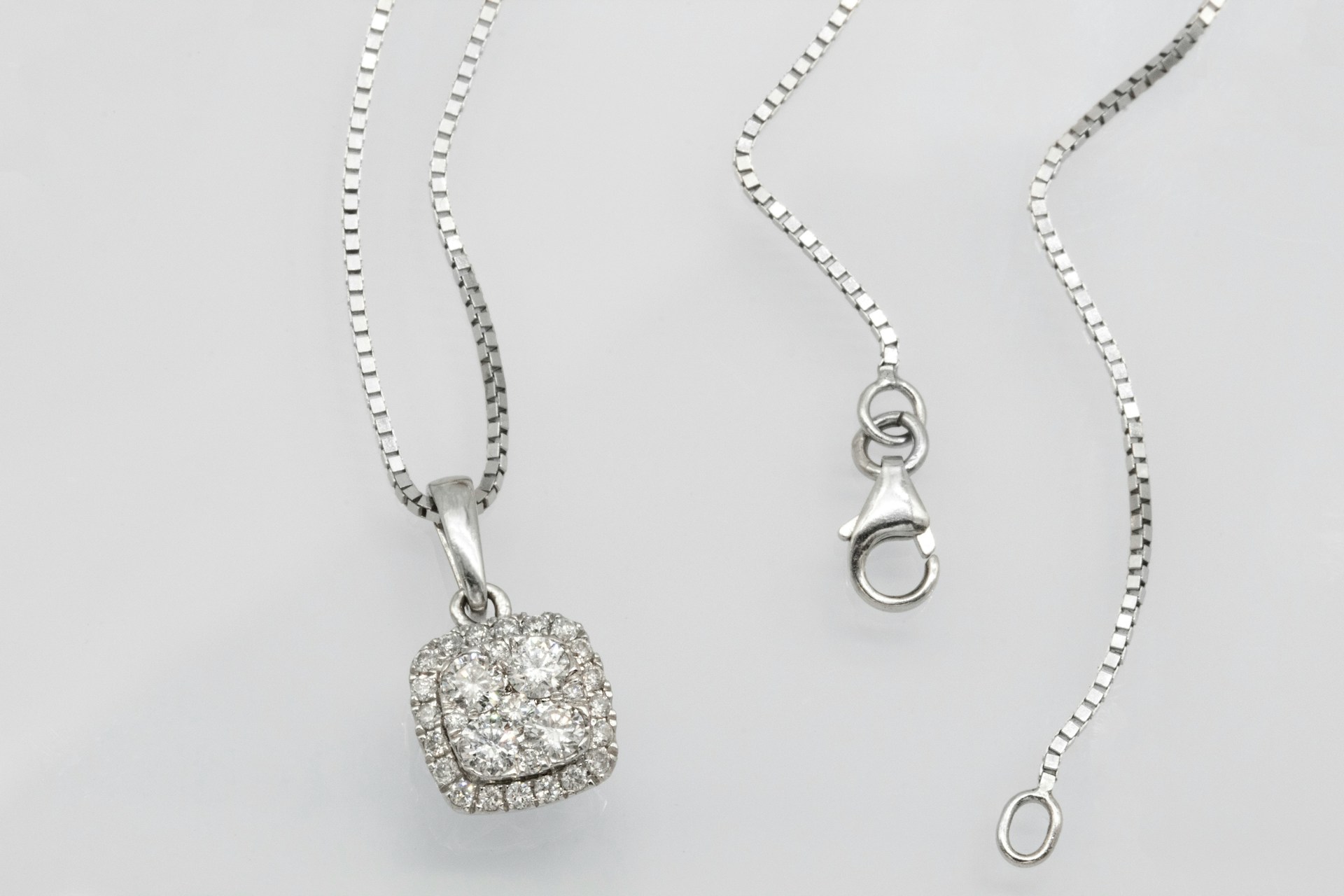 a platinum and diamond necklace on a gray background