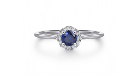 a white gold ring featuring a halo set sapphire center stone