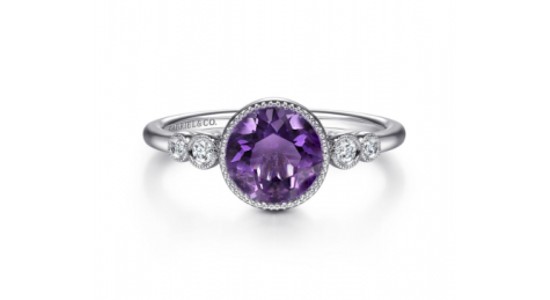 a white gold ring featuring a round cut amethyst and diamond accent stones