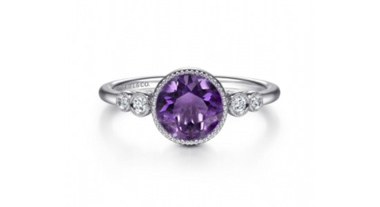 a white gold ring featuring a round cut amethyst and diamond accent stones