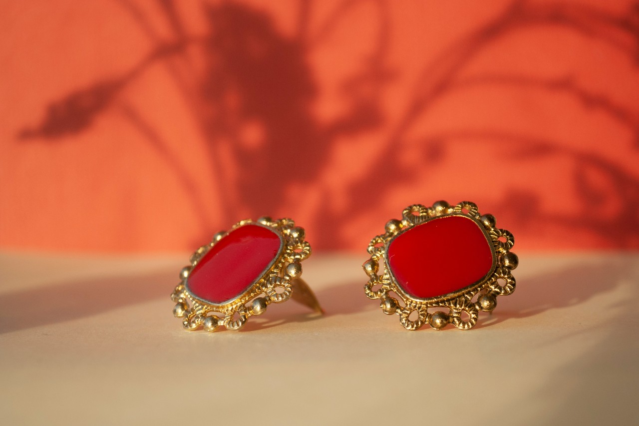 a pair of vintage yellow gold earrings with red ceramic centers