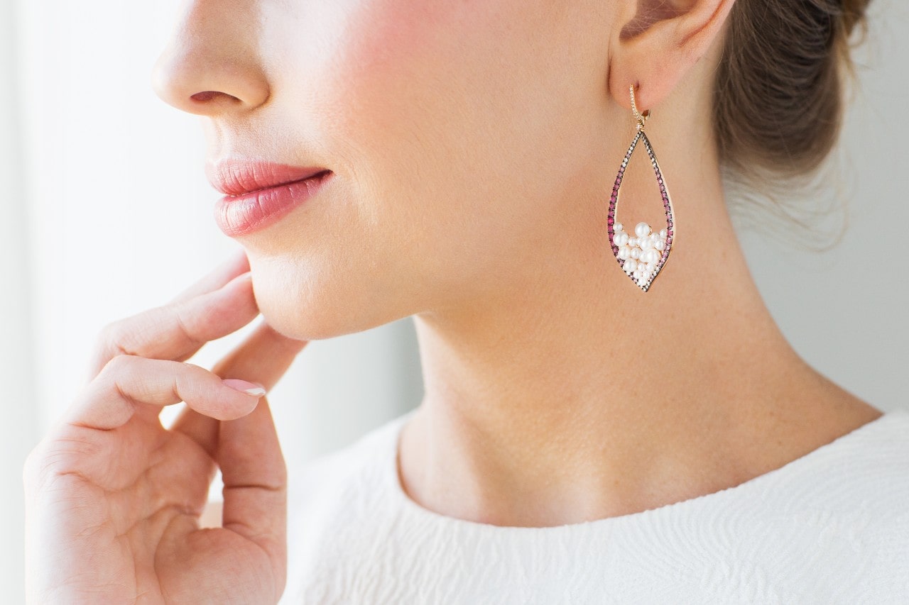 A woman wears a pair of drop earrings with an updo.