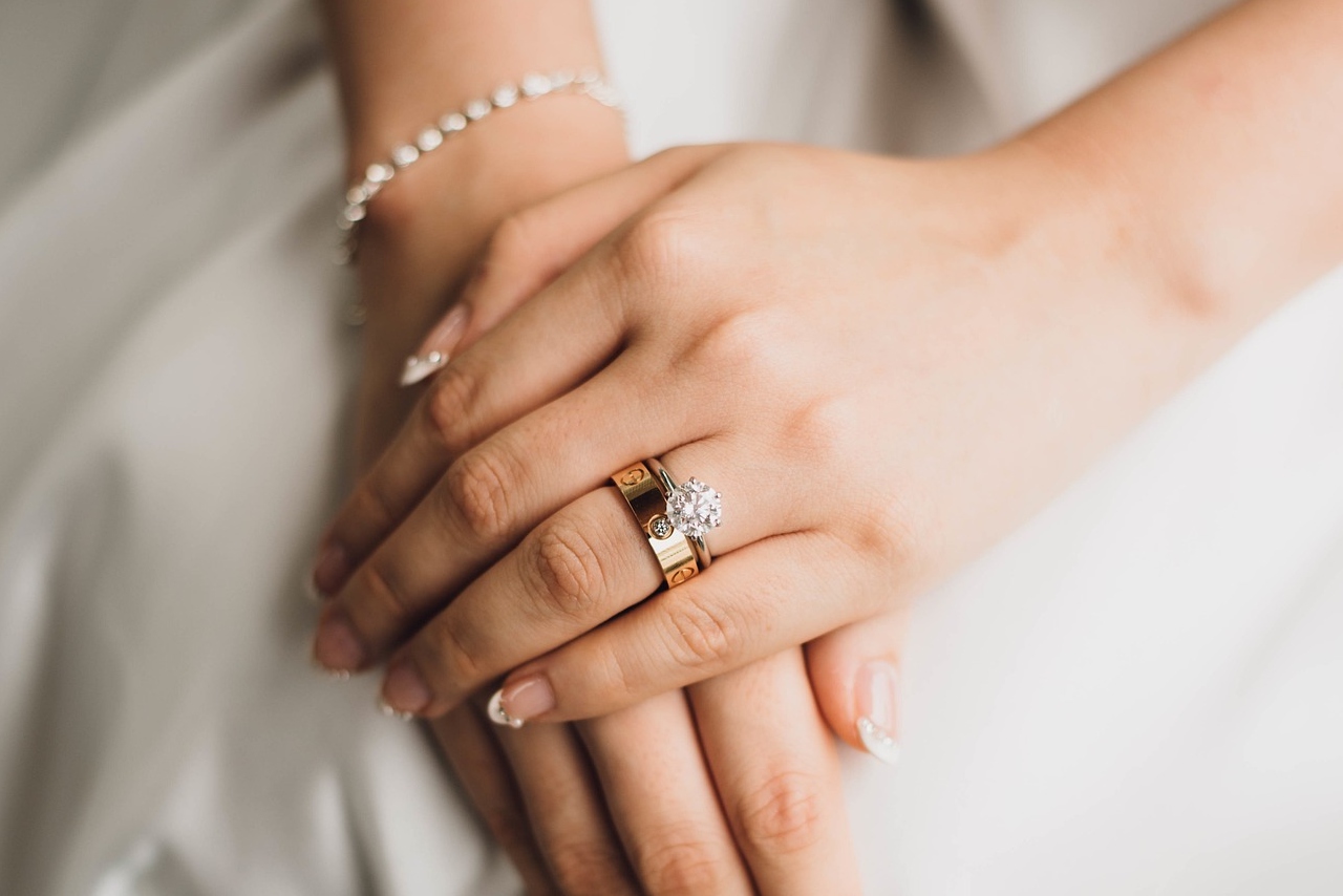 A bride wearing her engagement ring and wedding band with a close up on 