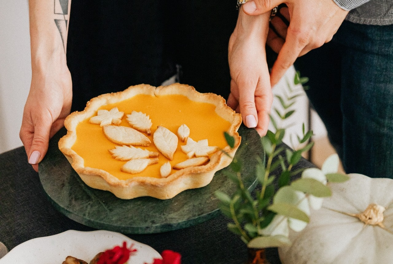 a table with a pumpkin pie being prepared for Thanksgiving