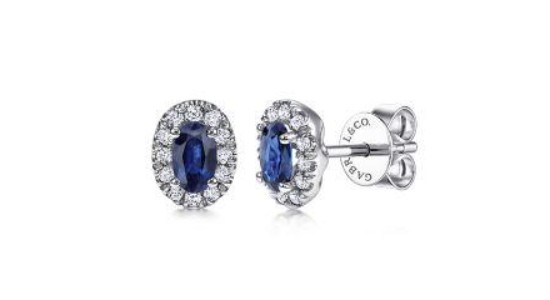 a pair of white gold stud earrings featuring oval cut sapphires and accent diamonds