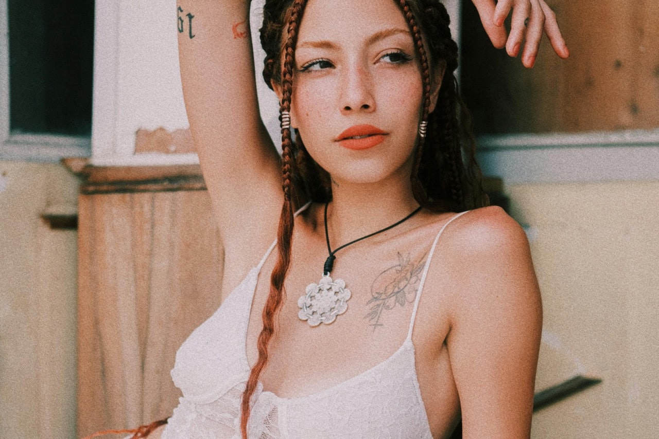 a woman wearing a large floral pendant necklace