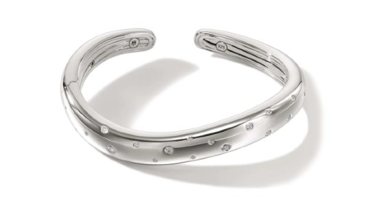 a silver toned cuff bracelet with diamond accents