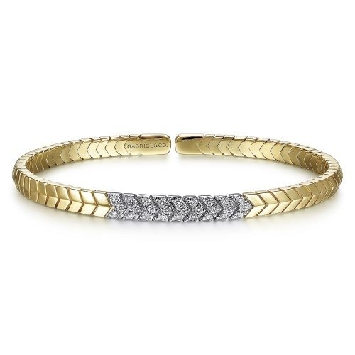 A yellow gold bracelet with a chevron pattern, featuring a central section of glistening diamonds.