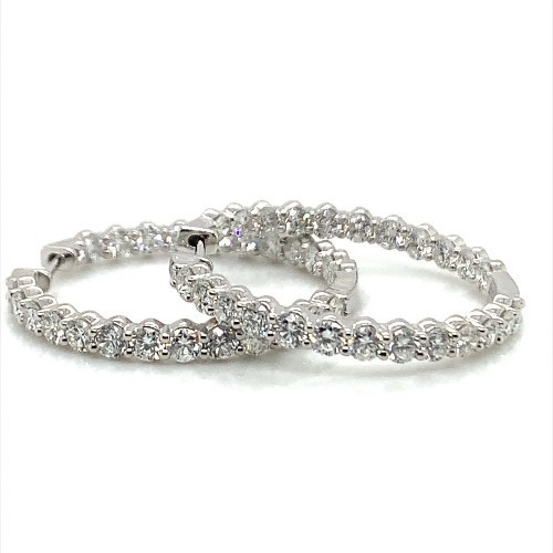 A pair of elegant silver hoop earrings encrusted with sparkling diamonds.