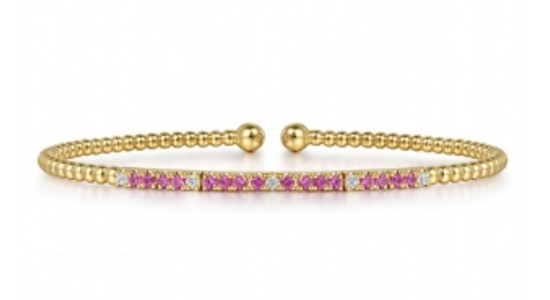 A yellow gold beaded bangle with pink rubies and diamonds from Gabriel & Co., available at Rottermond Jewelers.