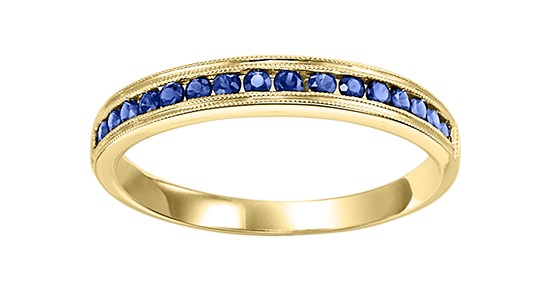 a yellow gold ring featuring deep blue sapphires in a channel setting