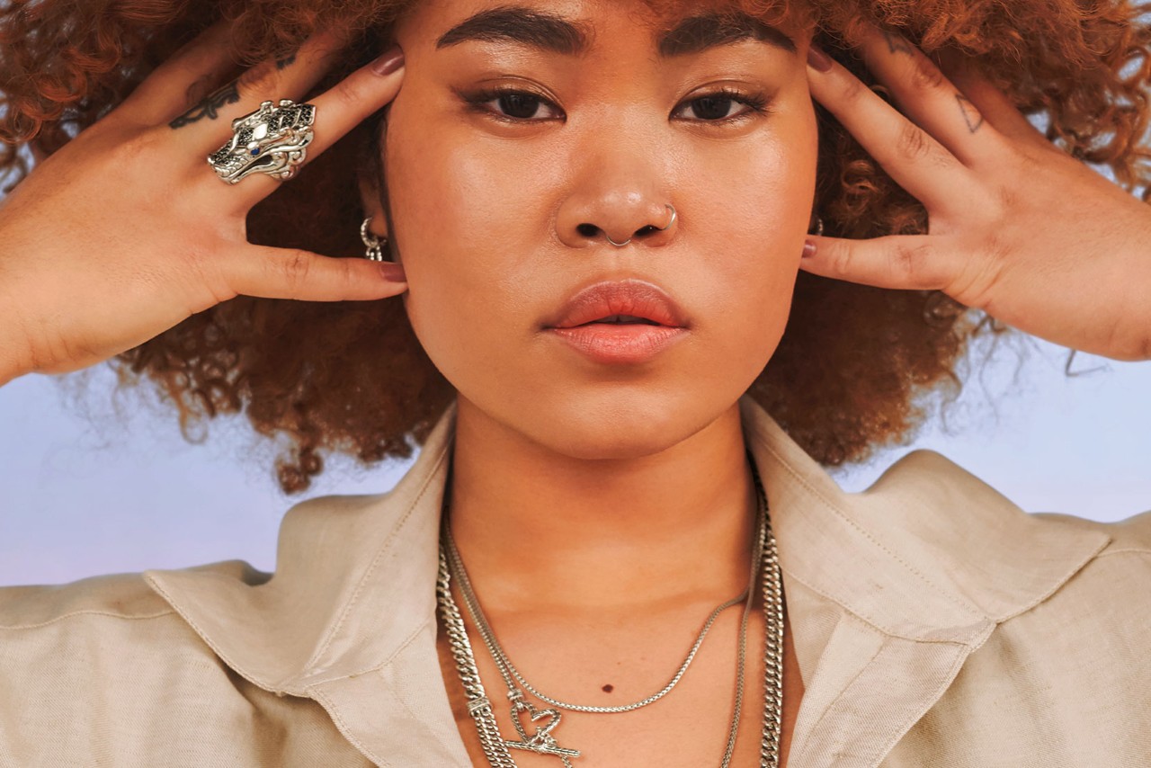 A woman wearing a ring, earrings, and necklaces by John Hardy