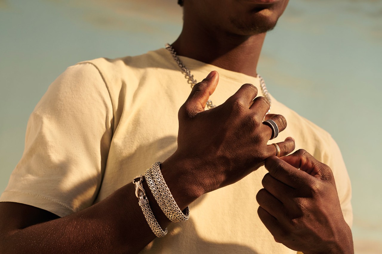 Man wearing chain bracelets and necklace along with fashion rings by John Hardy