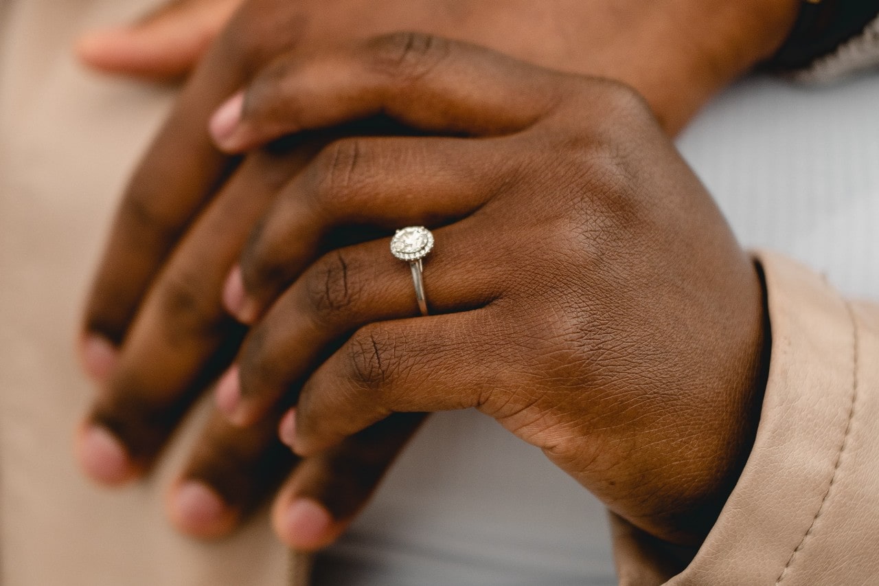 A closeup view of a woman’s oval-cut ring on her ring finger.