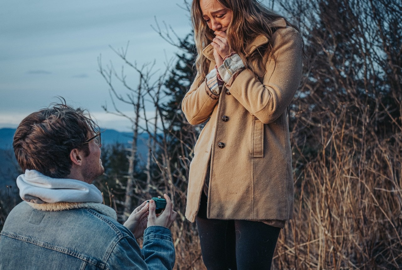 A man proposes to his partner while on a winter hike.