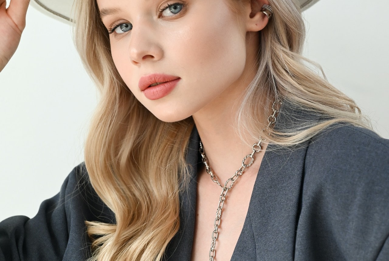 lady wearing a chain necklace and earrings