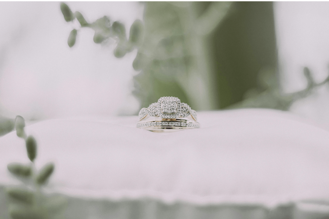 a matching engagement ring and wedding band set on a white pillow. a matching engagement ring and wedding band set on a white pillow.