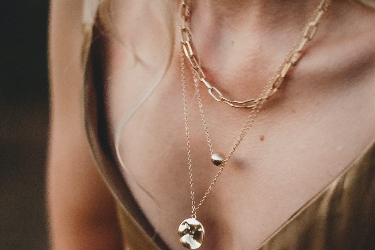 Woman wearing multiple yellow gold necklaces Woman wearing multiple yellow gold necklaces